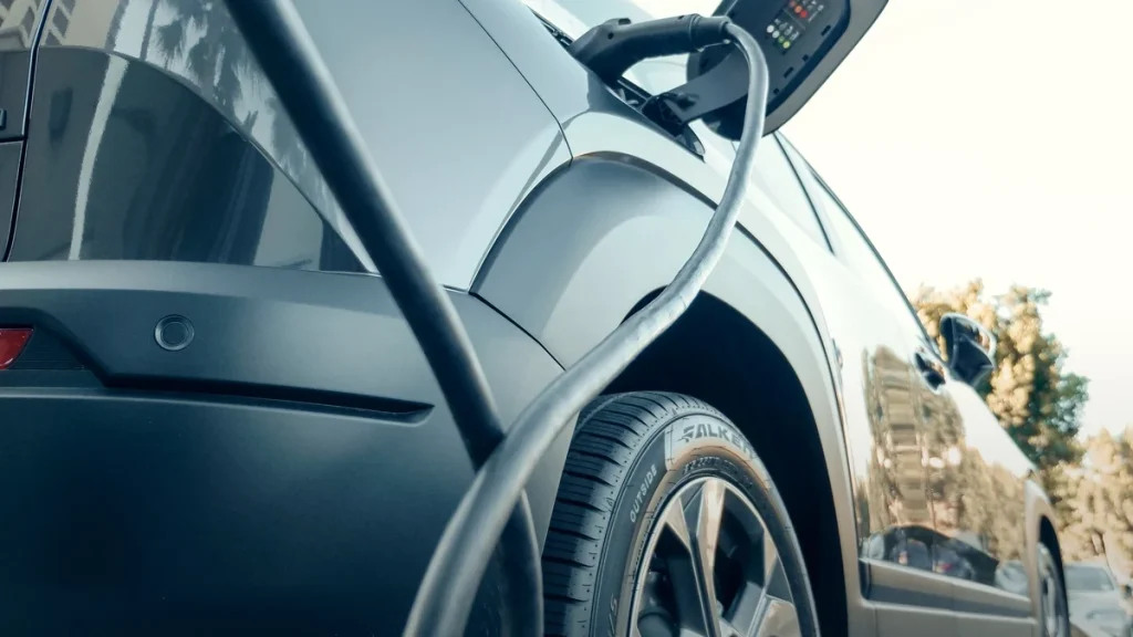 Przewód wpięty w gniazdo ładowania samochodu elektrycznego