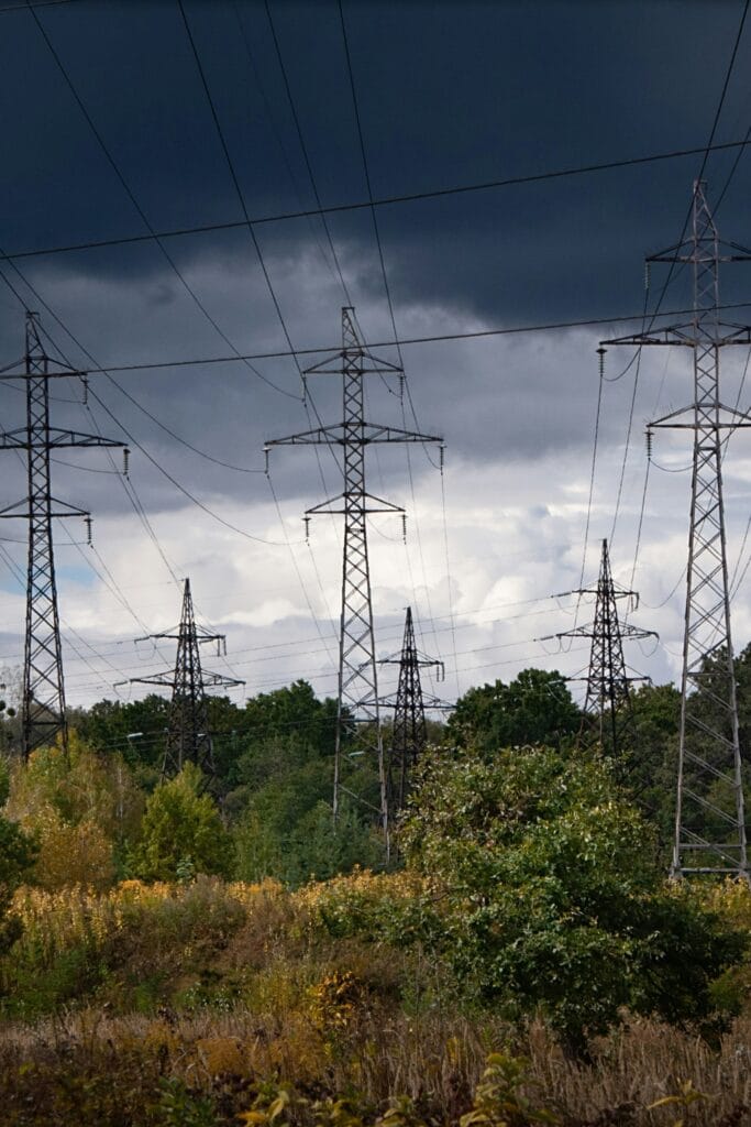 Ciemne burzowe niebo nad liniami energetycznymi - ilustracja do artykułu o rekordowym tygodniu cen energii