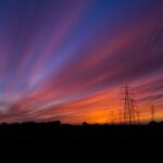 RCEm za wrzesień 2026 - ceny energii dla prosumentów, zachód słońca nad liniami wysokiego napięcia